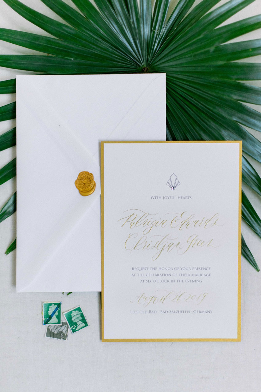 Hochzeitseinladung mit Siegelumschlag und goldener Kalligrafie